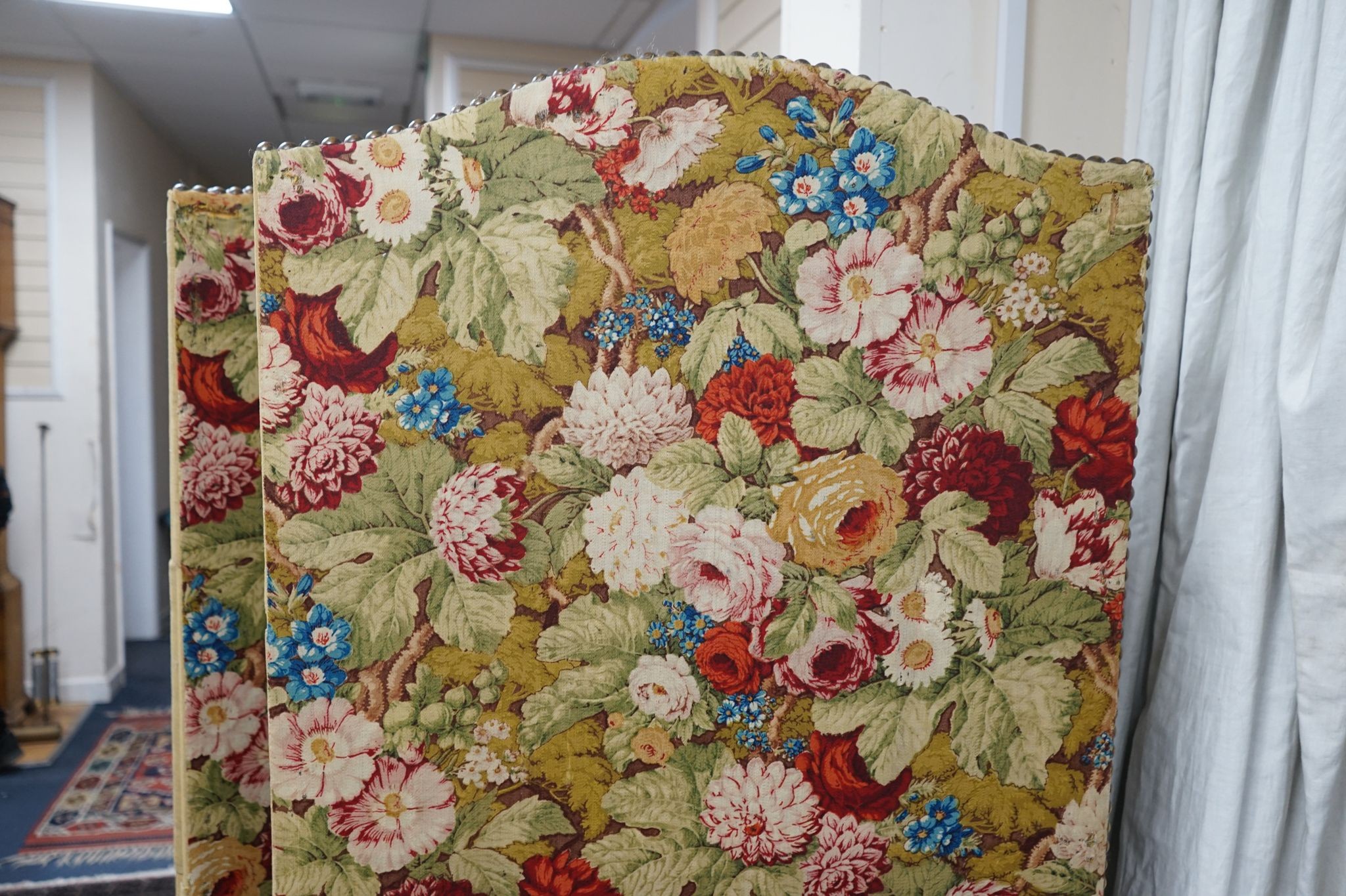 An early 20th century floral fabric four fold dressing screen, each panel width 67cm, height 176cm